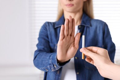 Woman refusing cigarette on light background, closeup. Quitting smoking concept