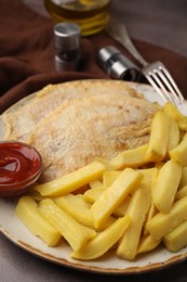 Photo of Delicious fish and chips with ketchup served on table, closeup
