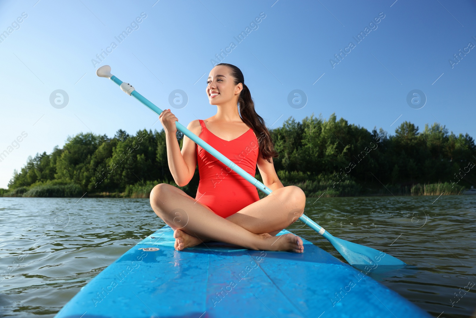 Photo of Woman paddle boarding on SUP board in river