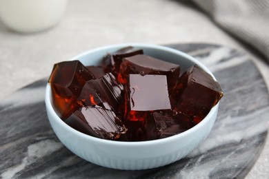 Photo of Delicious grass jelly cubes on board, closeup