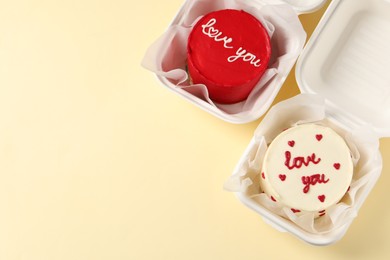 Photo of Bento cakes in takeaway boxes on beige table, flat lay. Space for text. St. Valentine's day surprise