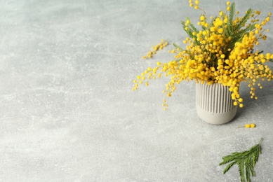 Bouquet of beautiful mimosa flowers on grey table