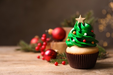 Christmas tree shaped cupcake on wooden table. Space for text