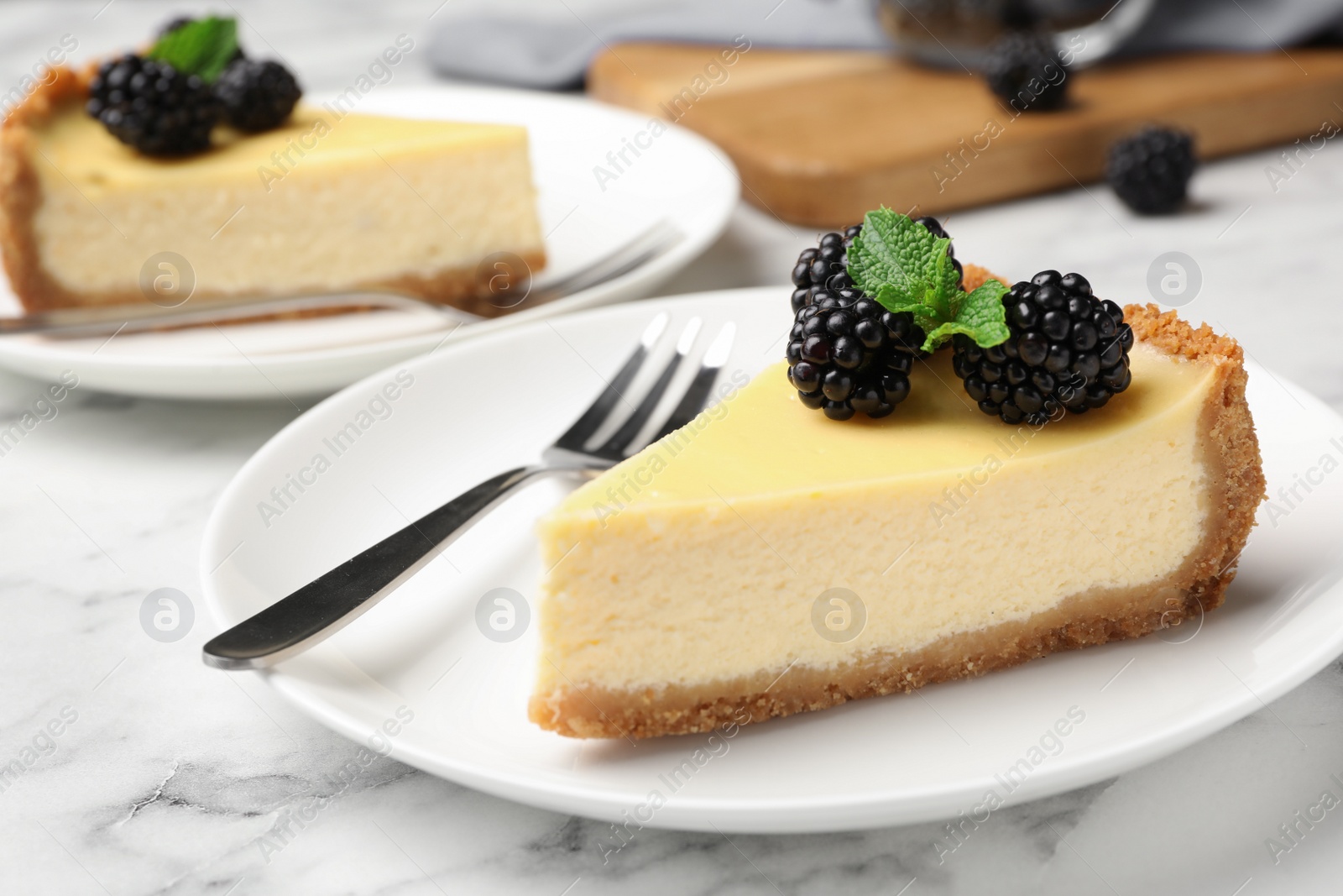 Photo of Piece of delicious cheesecake decorated with blackberries on table