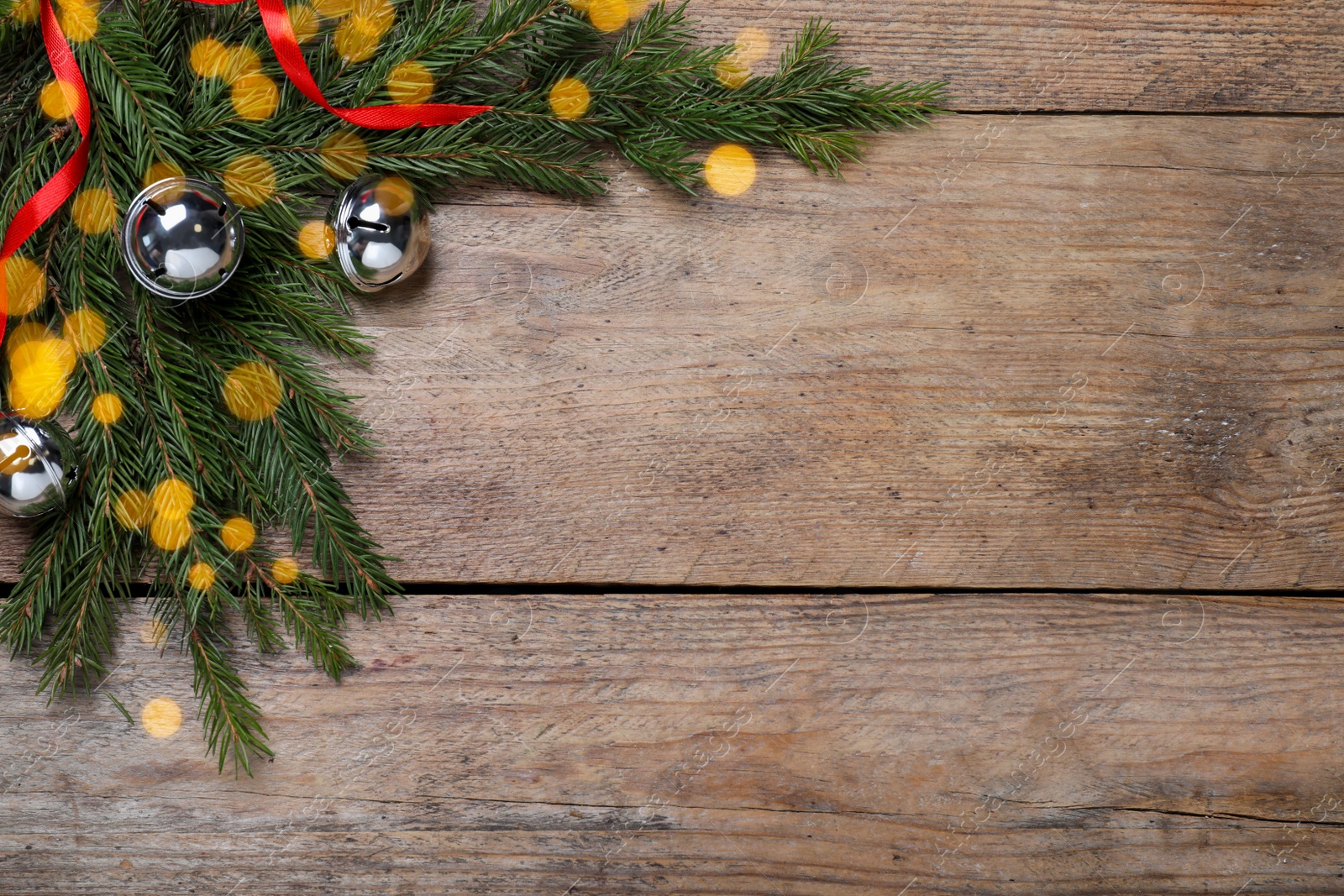 Photo of Christmas greeting card with space for text. Flat lay composition of fir tree branches and festive decor on wooden background