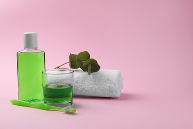 Photo of Composition with fresh mouthwash in bottle, glass and toothbrush on pink background. Space for text