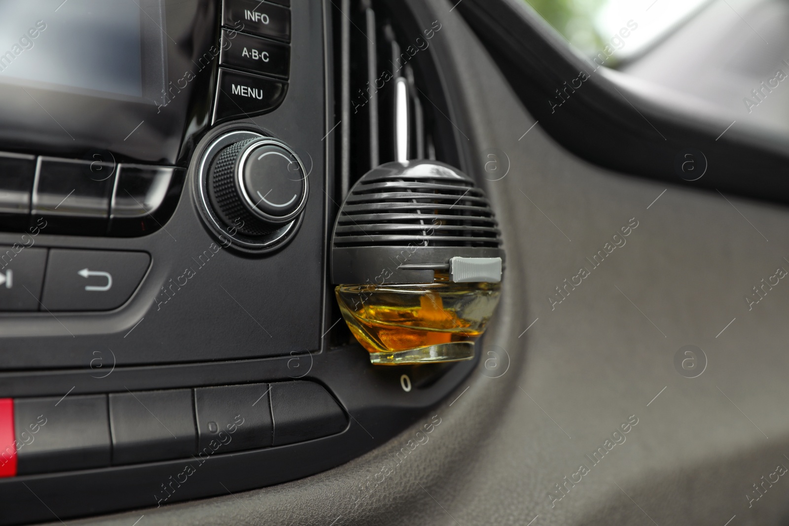 Photo of Stylish air freshener hanging near car ventilation