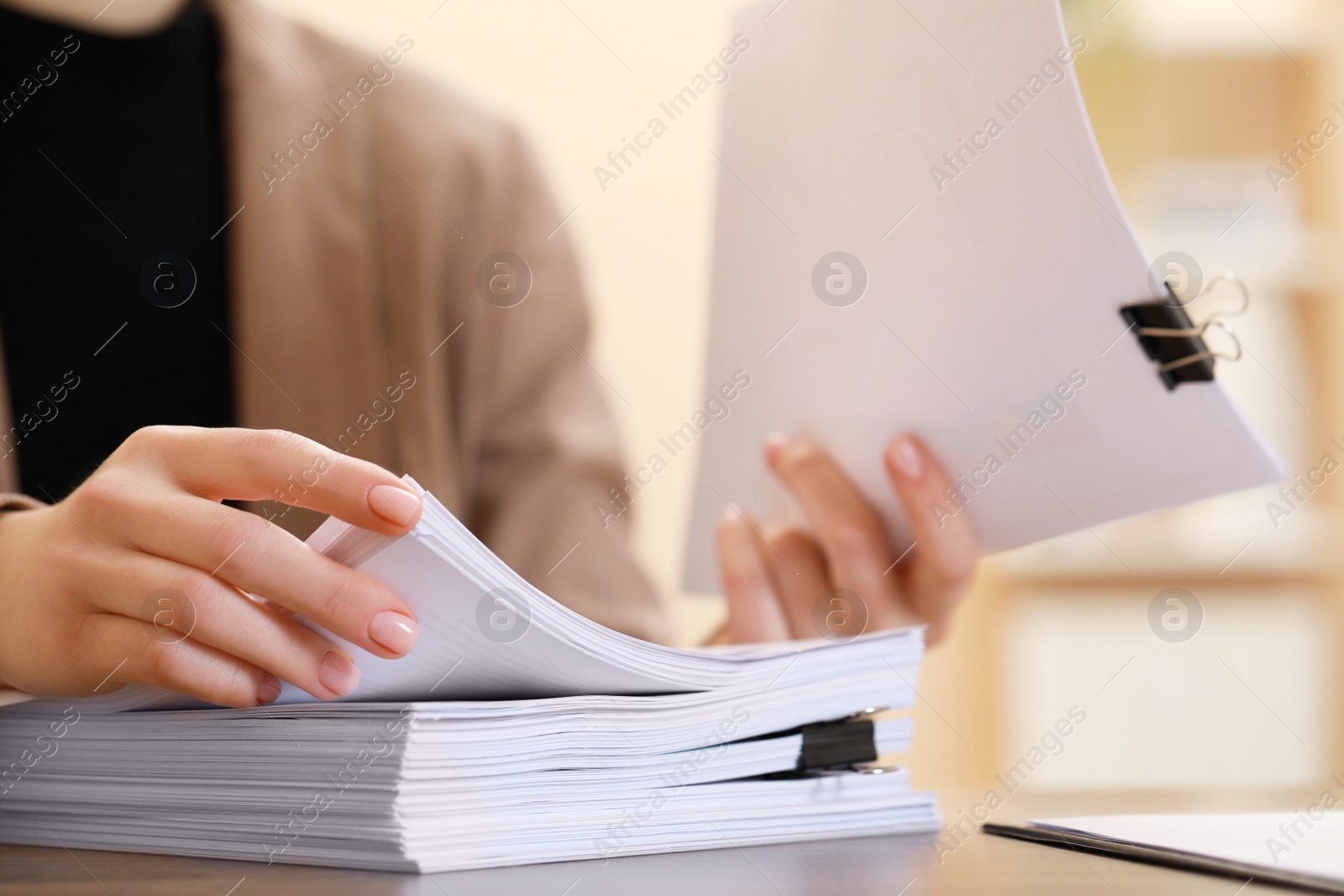 Photo of Woman working with documents at table in office, closeup