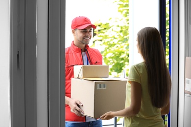Photo of Woman receiving parcels from courier on doorstep