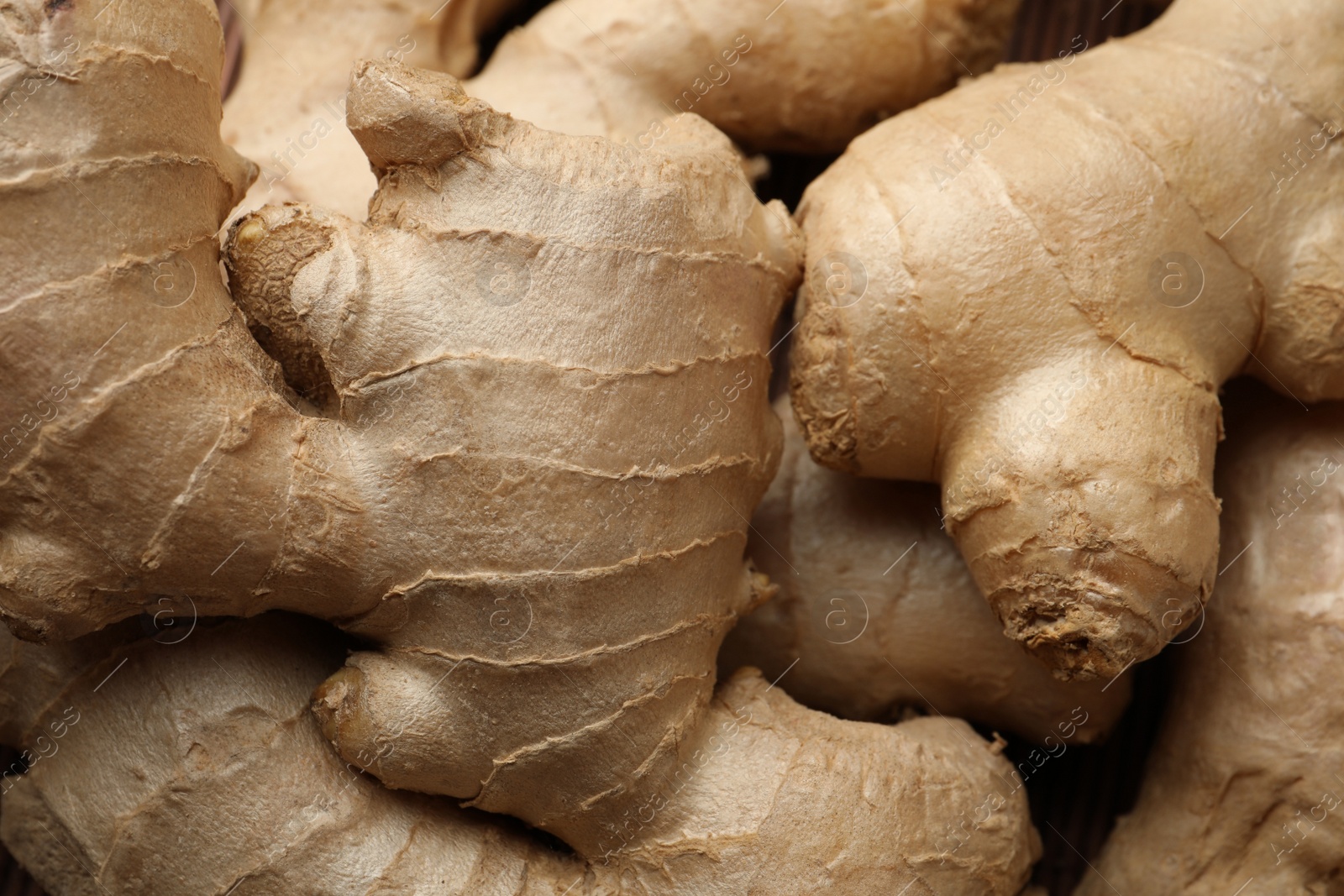 Photo of Aromatic fresh ginger as background, closeup view