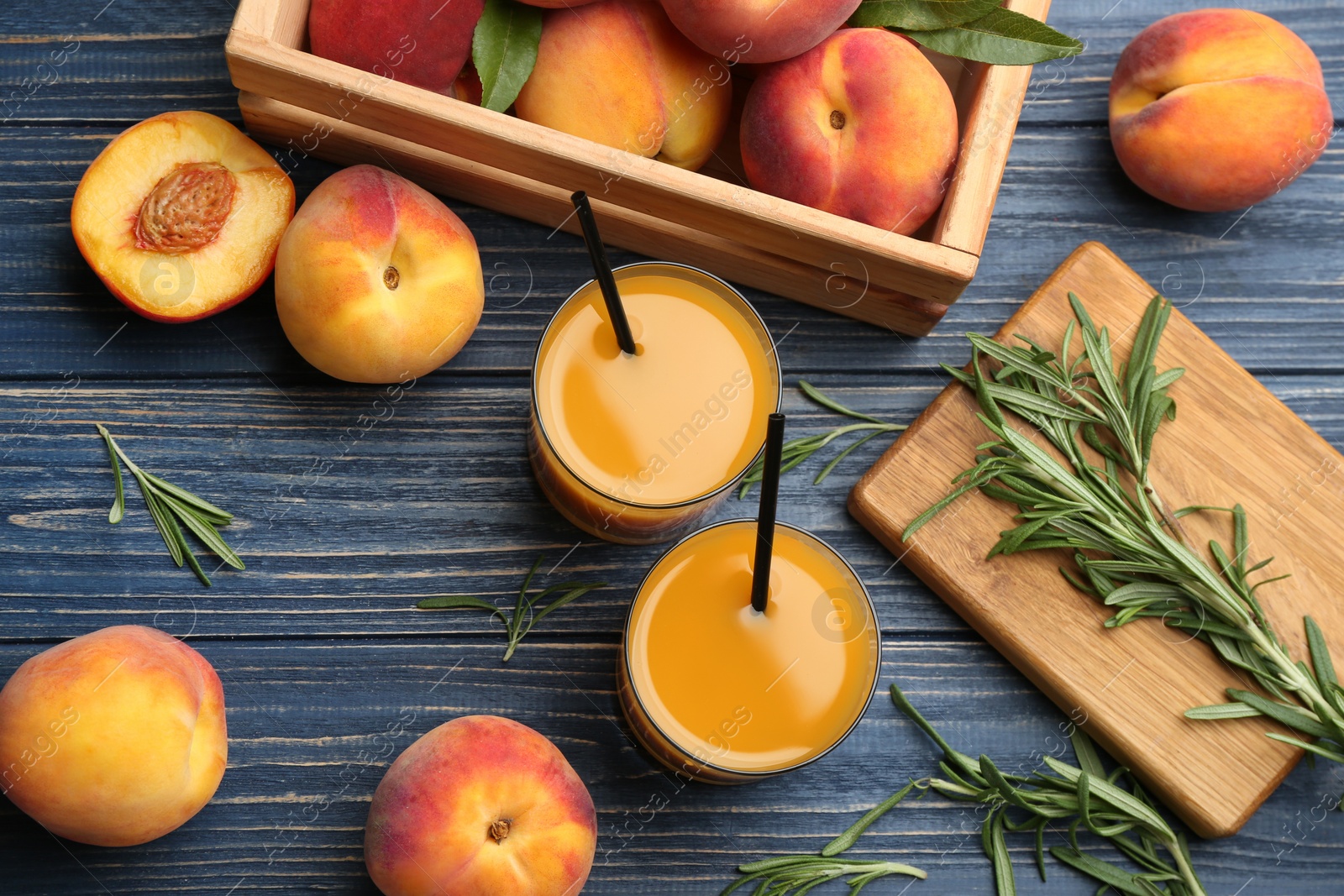 Photo of Natural peach juice and fresh fruits on blue wooden table, flat lay