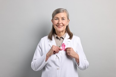 Mammologist with pink ribbon on gray background. Breast cancer awareness