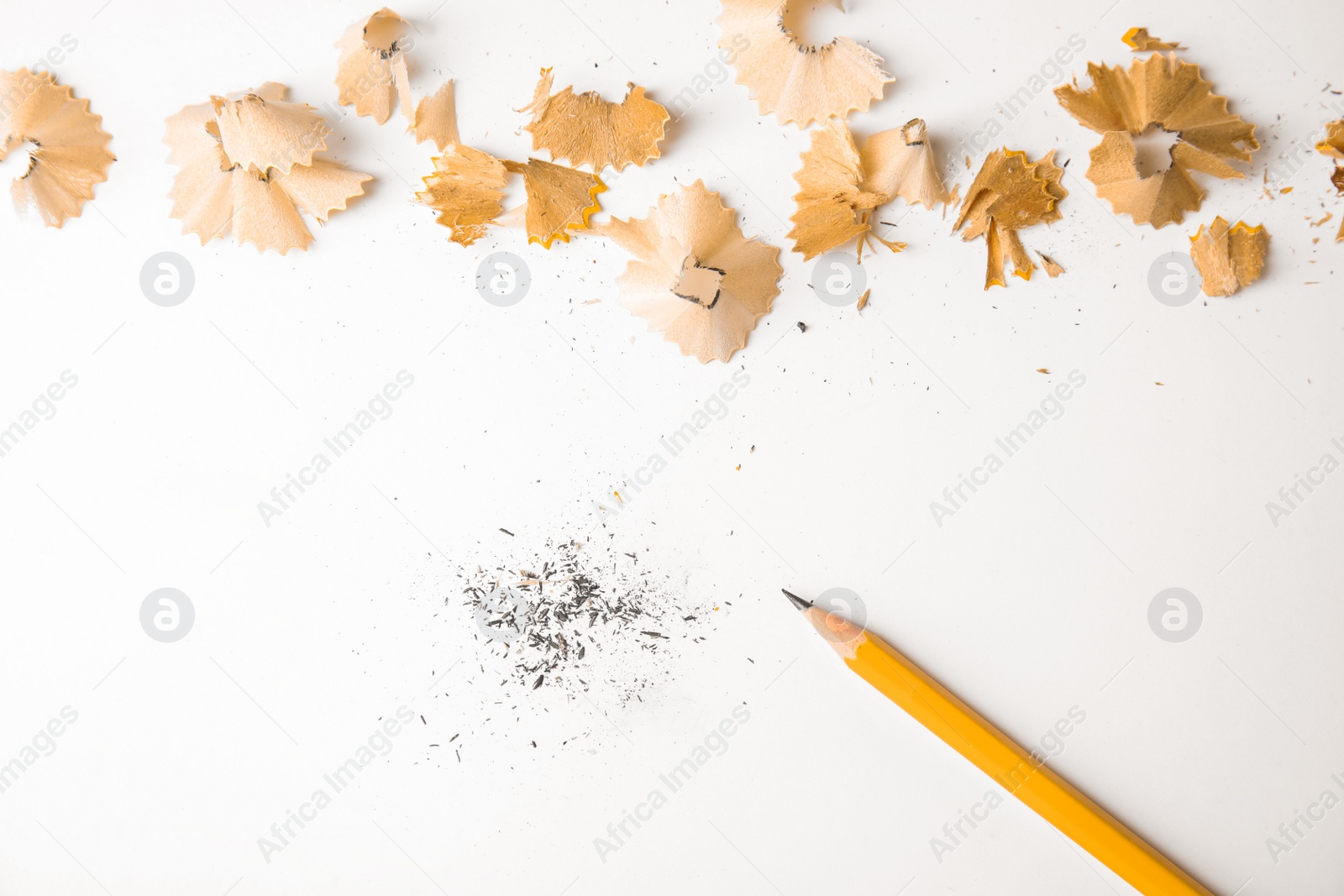 Photo of Pencil and shavings on white background, top view