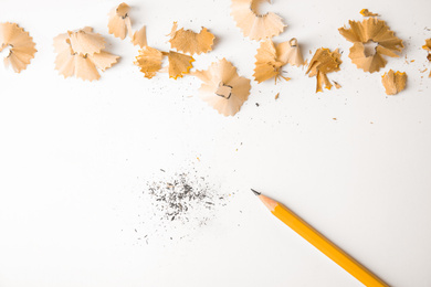 Photo of Pencil and shavings on white background, top view