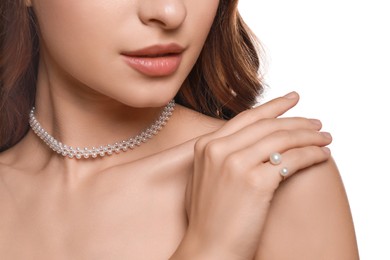 Photo of Young woman wearing elegant pearl jewelry on white background, closeup