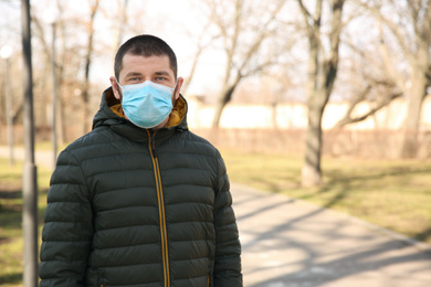 Photo of Man wearing disposable mask outdoors. Dangerous virus