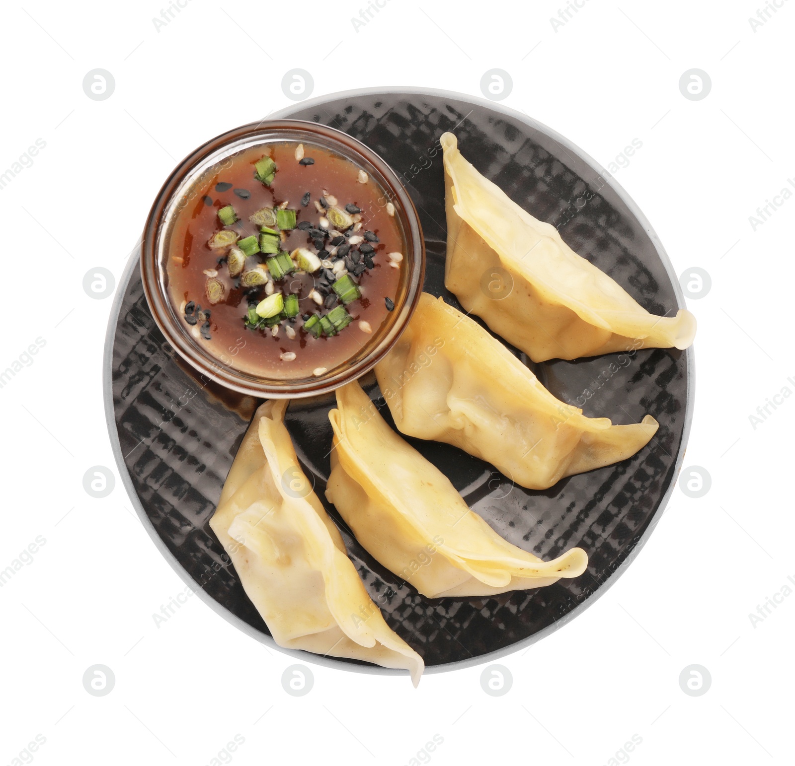 Photo of Delicious gyoza (asian dumplings) with sauce, onion and sesame isolated on white, top view