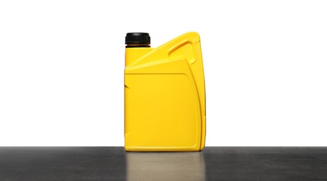Photo of Motor oil in yellow container on grey table against white background