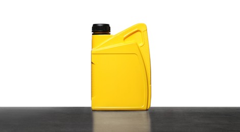 Motor oil in yellow container on grey table against white background