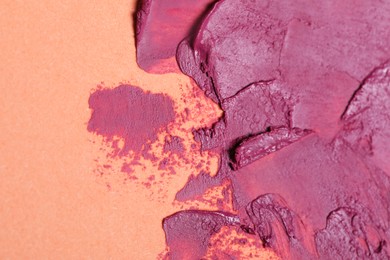 Photo of Smears of beautiful lipstick on beige background, closeup