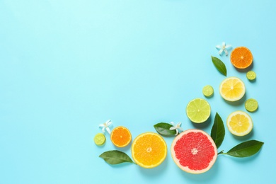 Photo of Frame made of different citrus fruits and leaves on color background, flat lay. Space for text