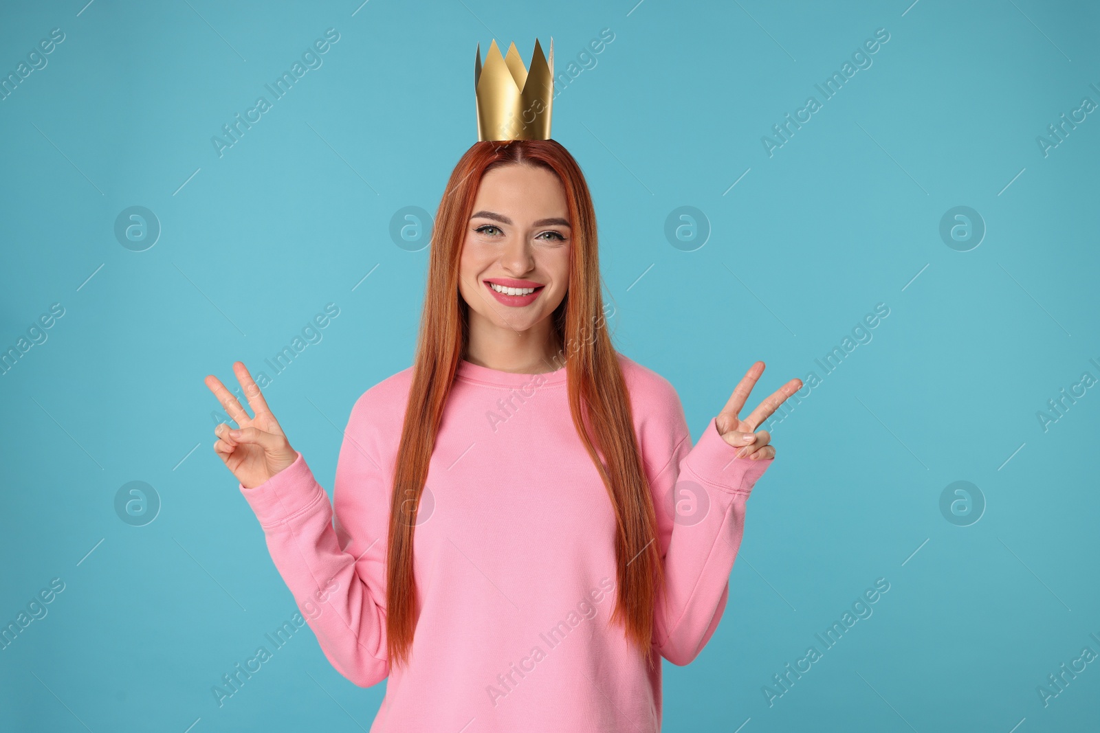 Photo of Beautiful young woman with princess crown on light blue background