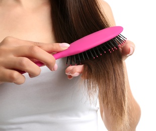 Woman with hair brush on white background, closeup