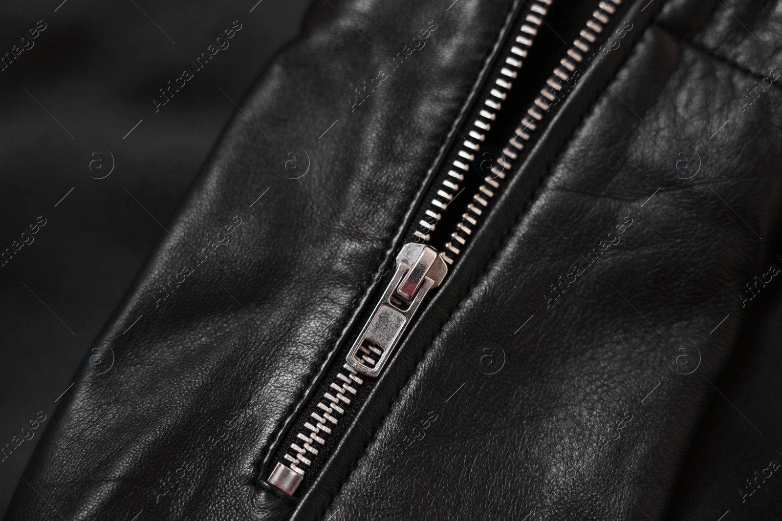 Photo of Texture of black leather jacket with zipper as background, top view