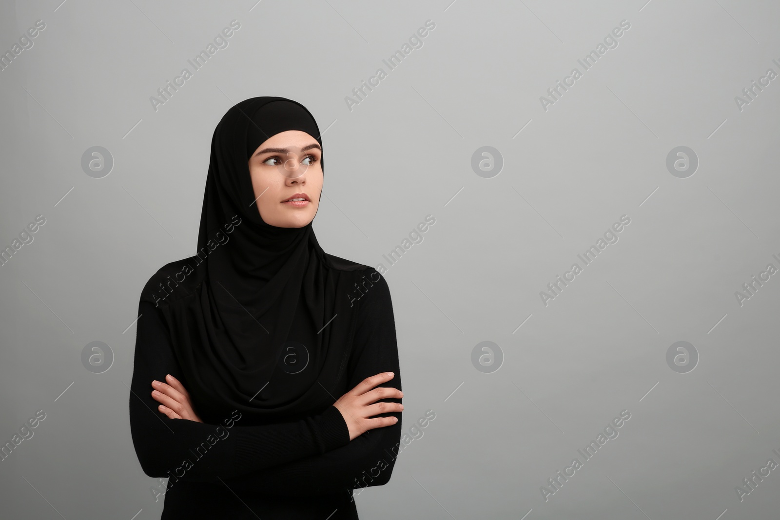 Photo of Portrait of Muslim woman in hijab on light gray background, space for text