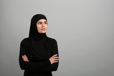 Photo of Portrait of Muslim woman in hijab on light gray background, space for text