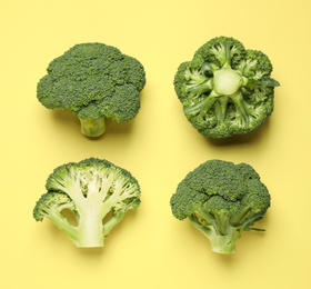 Photo of Fresh tasty broccoli on yellow background, flat lay