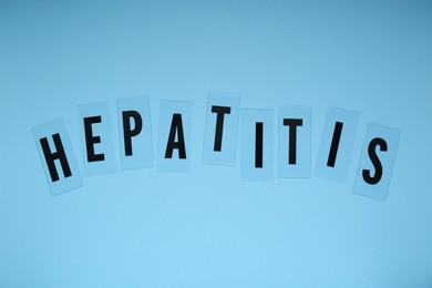 Photo of Word Hepatitis on light blue background, flat lay