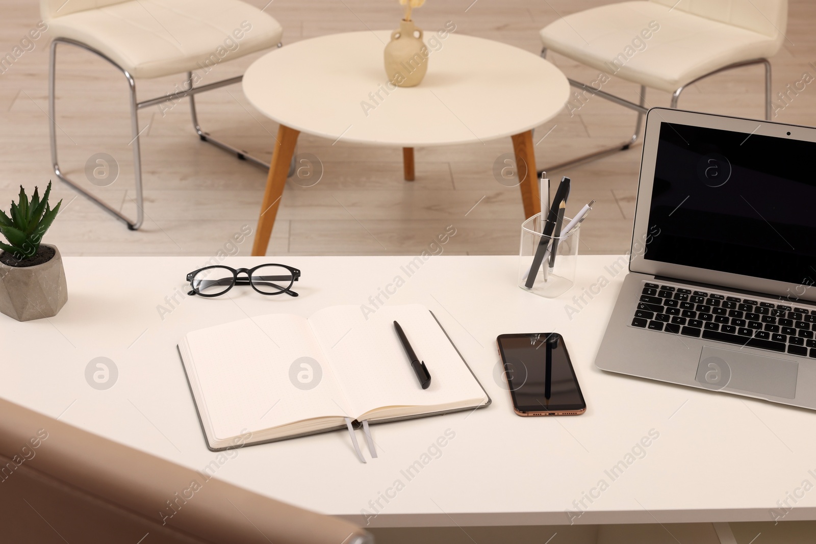 Photo of Cozy receptionist workspace with laptop on desk in office