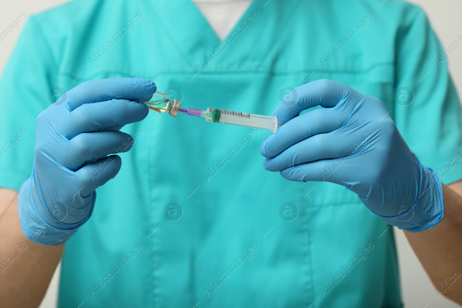 Photo of Doctor filling syringe with hepatitis vaccine from glass vial on grey background, closeup