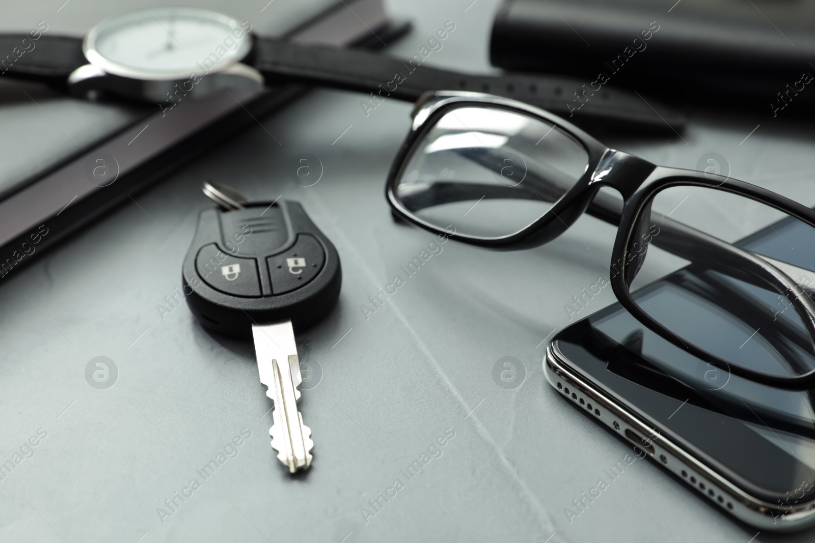 Photo of Composition with male accessories and car key on grey background