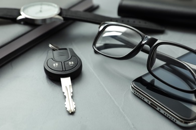 Composition with male accessories and car key on grey background