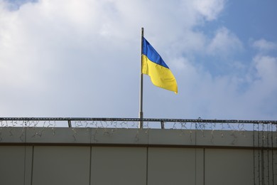 Photo of Ukrainian flag on building against cloudy sky