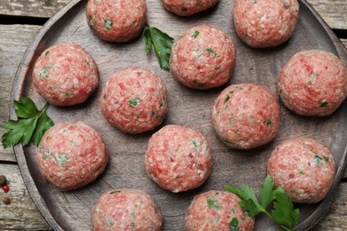 Many fresh raw meatballs on wooden table, flat lay