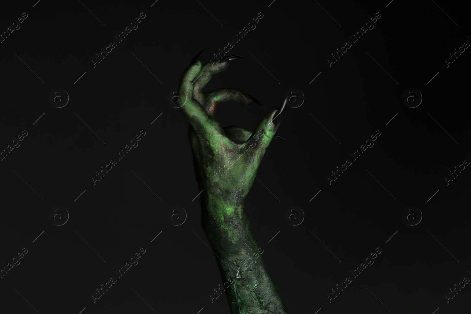 Photo of Scary monster on black background, closeup of hand. Halloween character