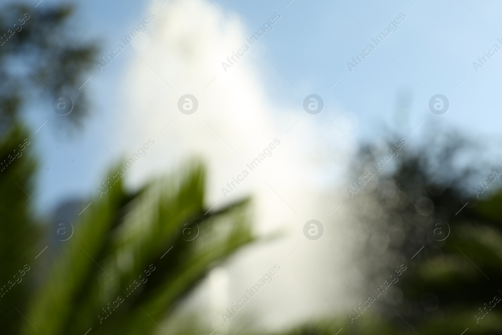 Photo of Blurred view of water fountain on sunny day outdoors. Bokeh effect