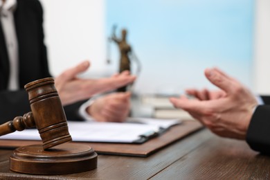 Photo of Woman having meeting with lawyer in office, focus on gavel