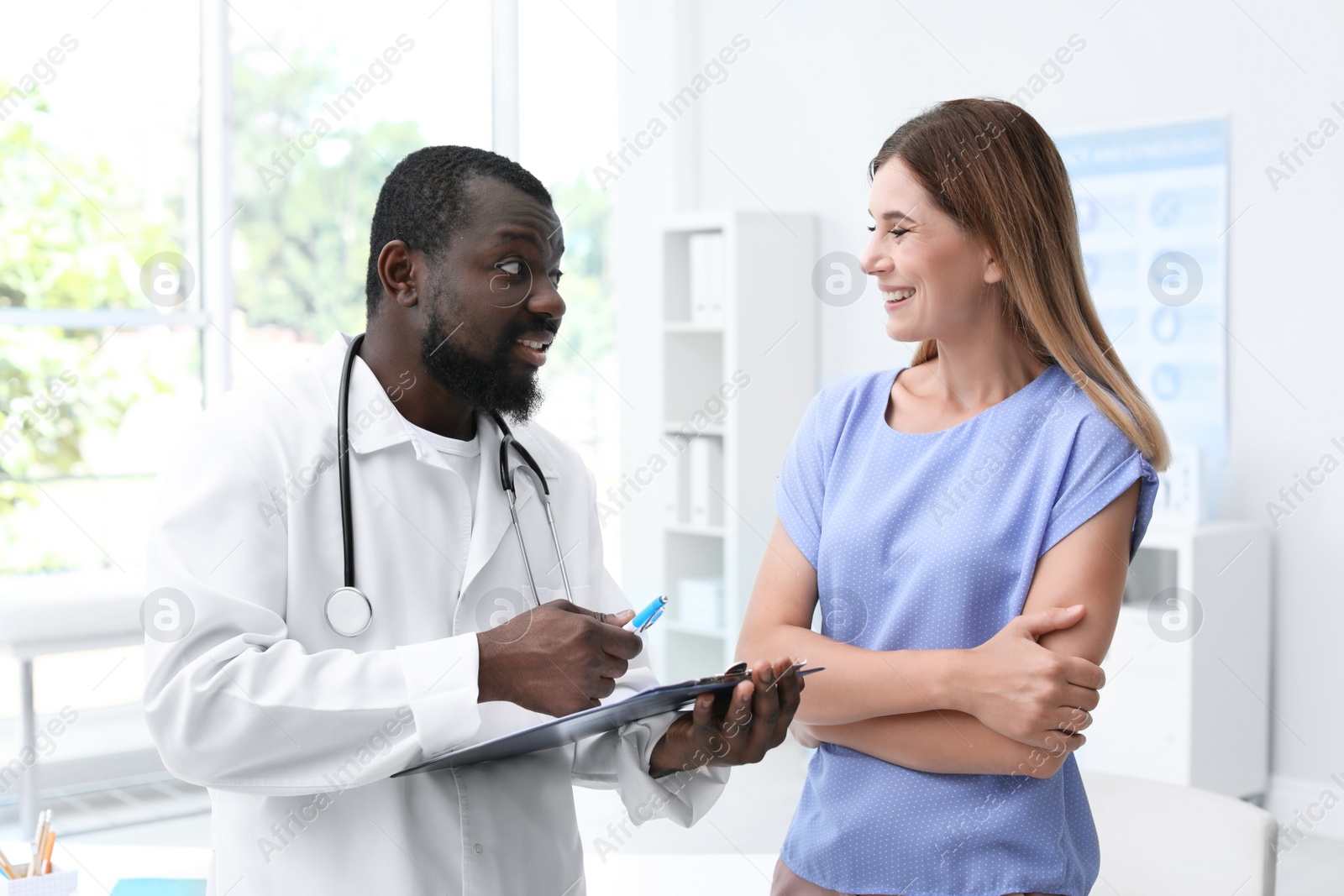 Photo of Young African-American doctor consulting patient in modern hospital