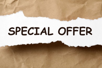 Image of Torn sheet of paper with phrase Special Offer on crumpled beige background, top view