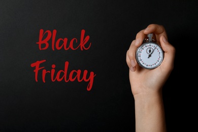Photo of Phrase Black Friday and woman holding timer against dark background, closeup