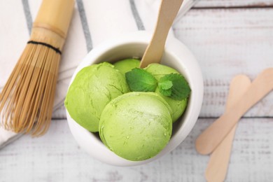 Photo of Tasty matcha ice cream in bowl on white wooden table, flat lay