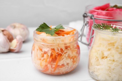 Photo of Delicious sauerkraut prepared according to different recipes on white table, closeup