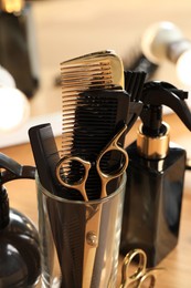 Photo of Set of hairdresser tools on table in salon, closeup