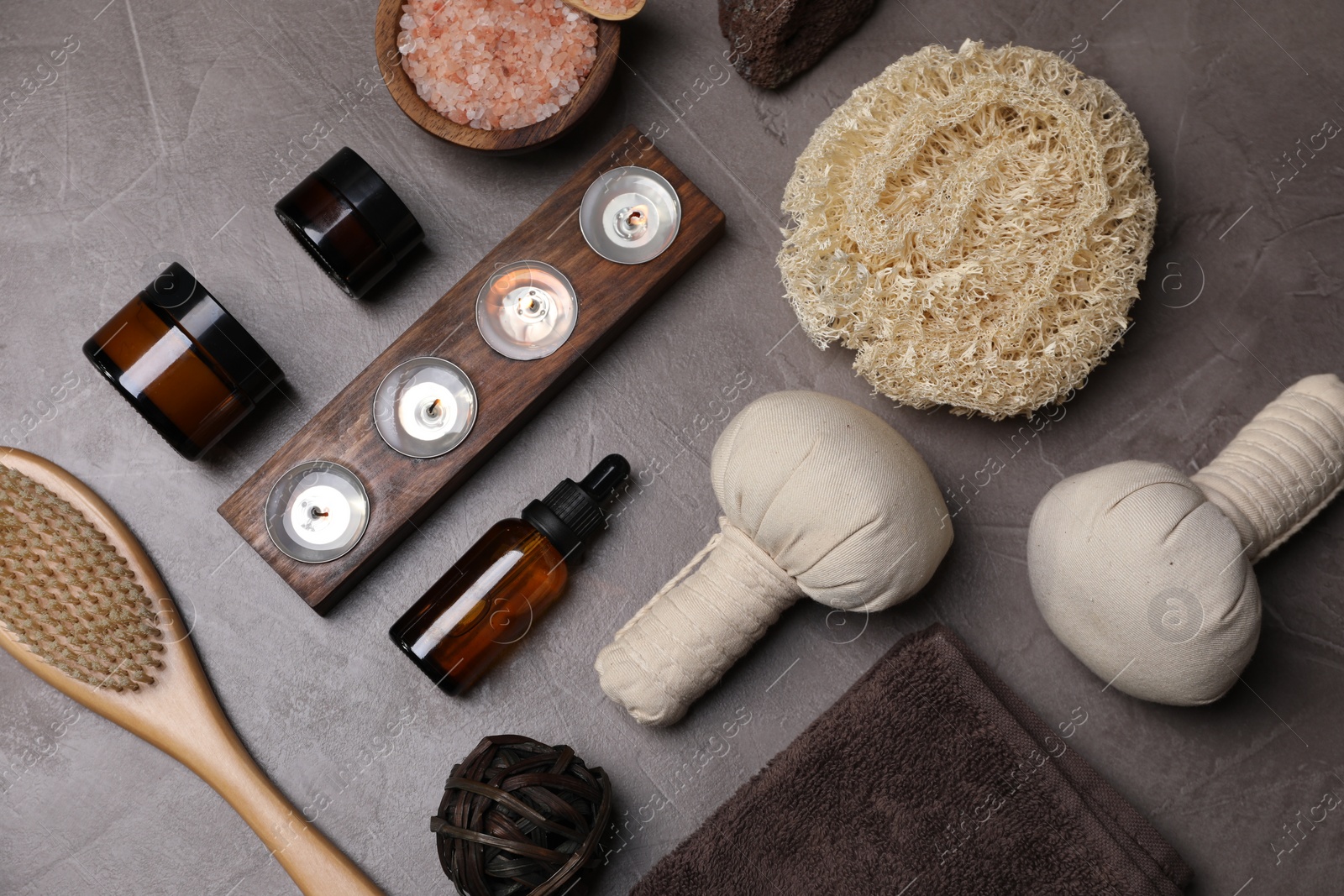 Photo of Flat lay composition with different spa products and burning candles on grey textured table