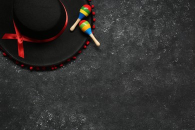 Mexican sombrero hat and maracas on grey textured background, flat lay. Space for text