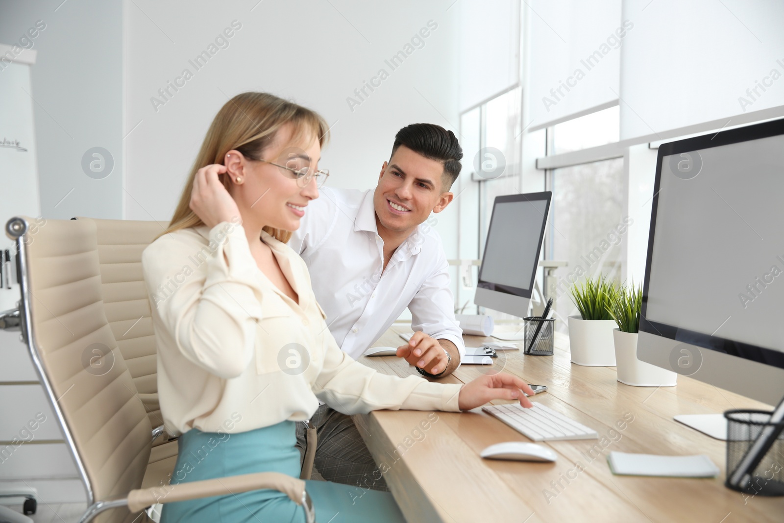 Photo of Man flirting with his colleague during work in office